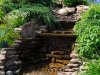 Искусственный водопад на пруду загородного участка.